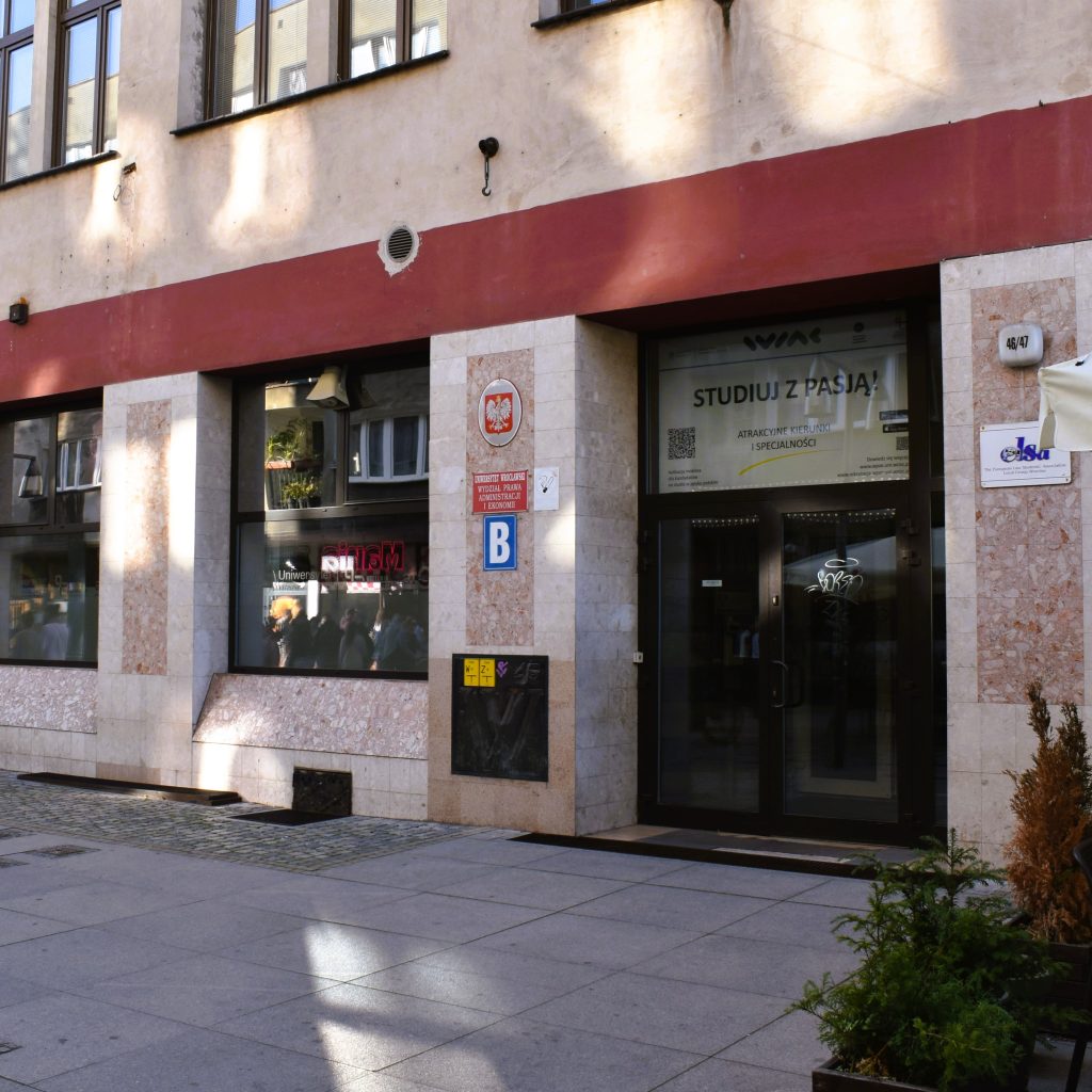 Wejście do Sekretariatu Szkoły Doktorskiej, budynek z dwoma dużymi oknami i podwójnymi drzwiami, wejście z poziomu ulicy.