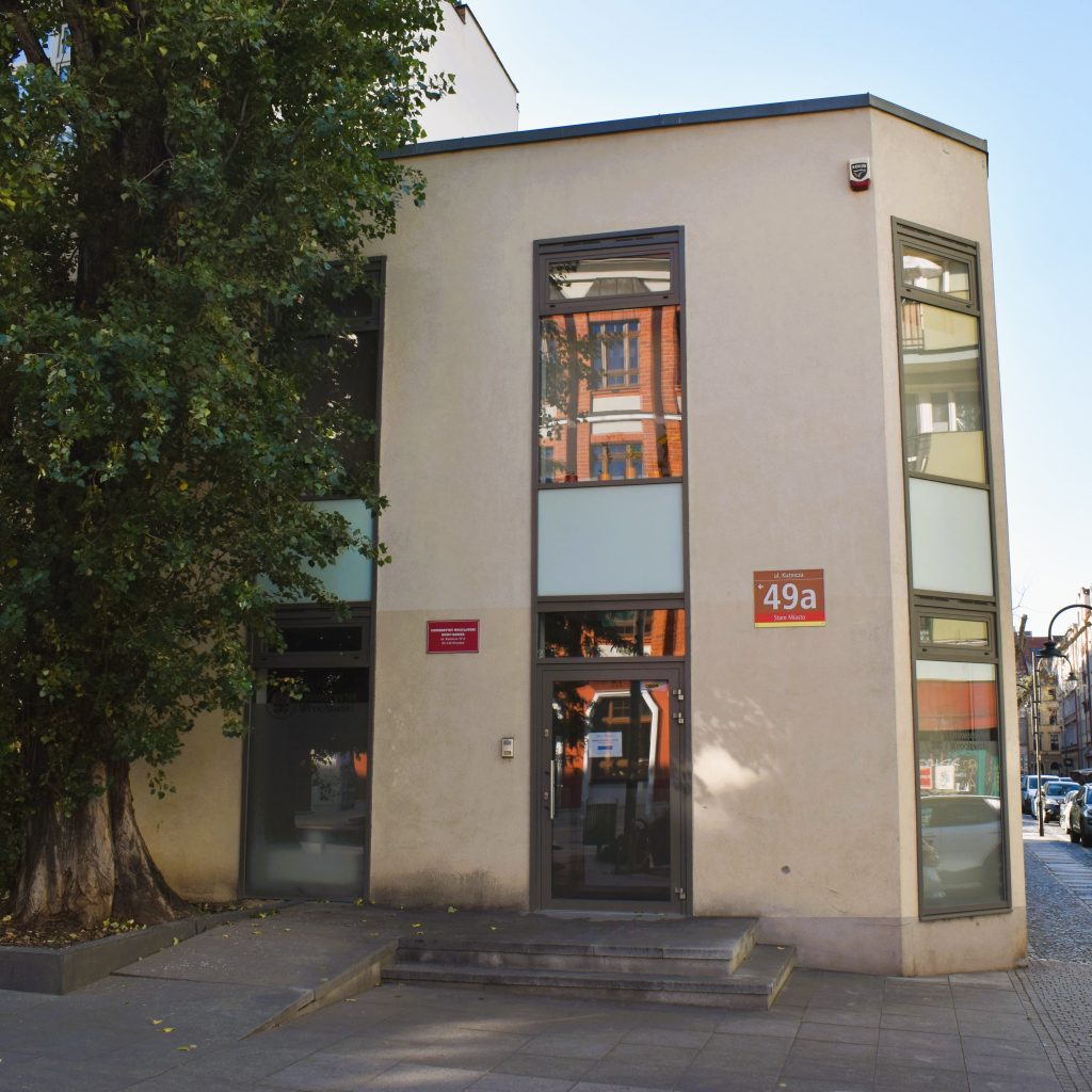 budynek Akademickiego Biura Karier na rogu, niewielki piętrowy budynek z łagodnym podjazdem i dwoma schodkami (odrębne drogi)